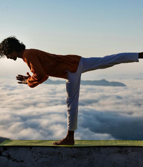 Person stretching outdoors at sunrise, feeling calm and balanced.